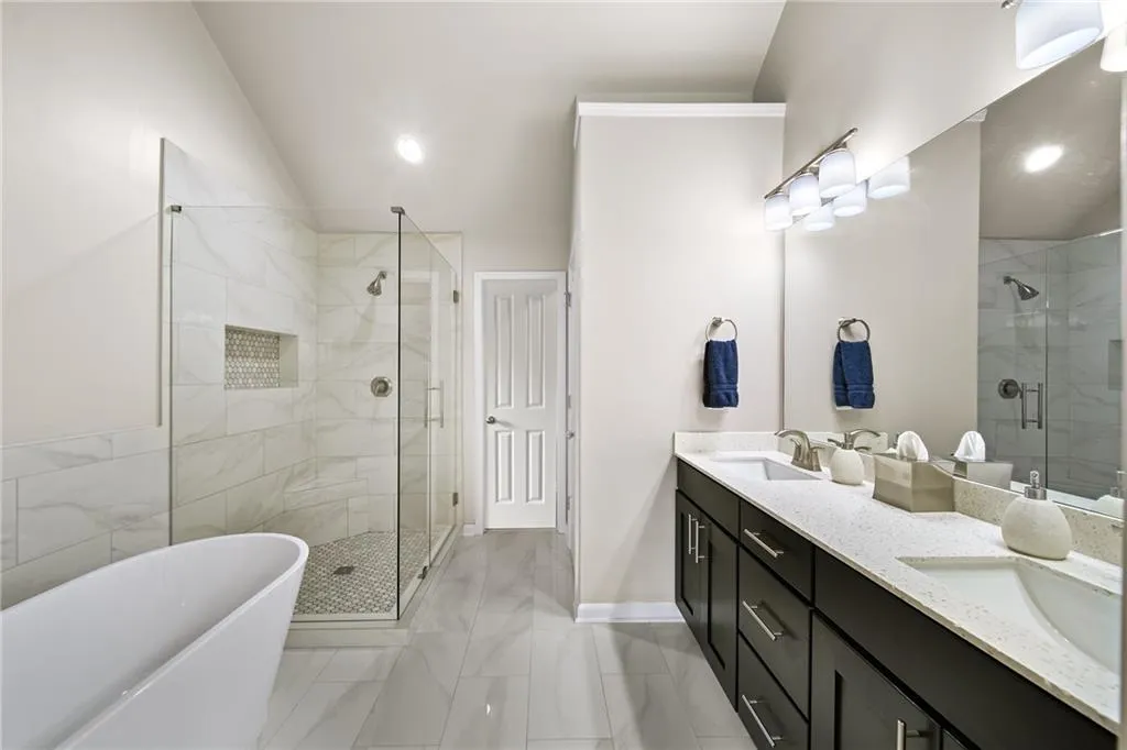 Bathroom featuring vanity, shower with separate bathtub, and vaulted ceiling