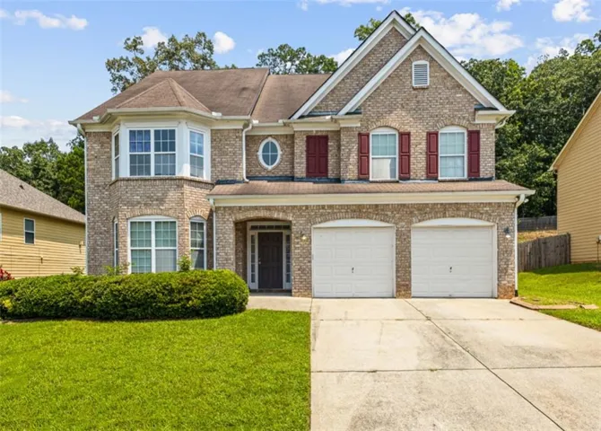 Traditional brick exterior featuring a two-story design with a prominent bay window