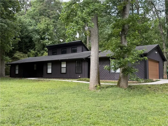 Dark-stained vertical siding with a contrasting wood-finish garage door