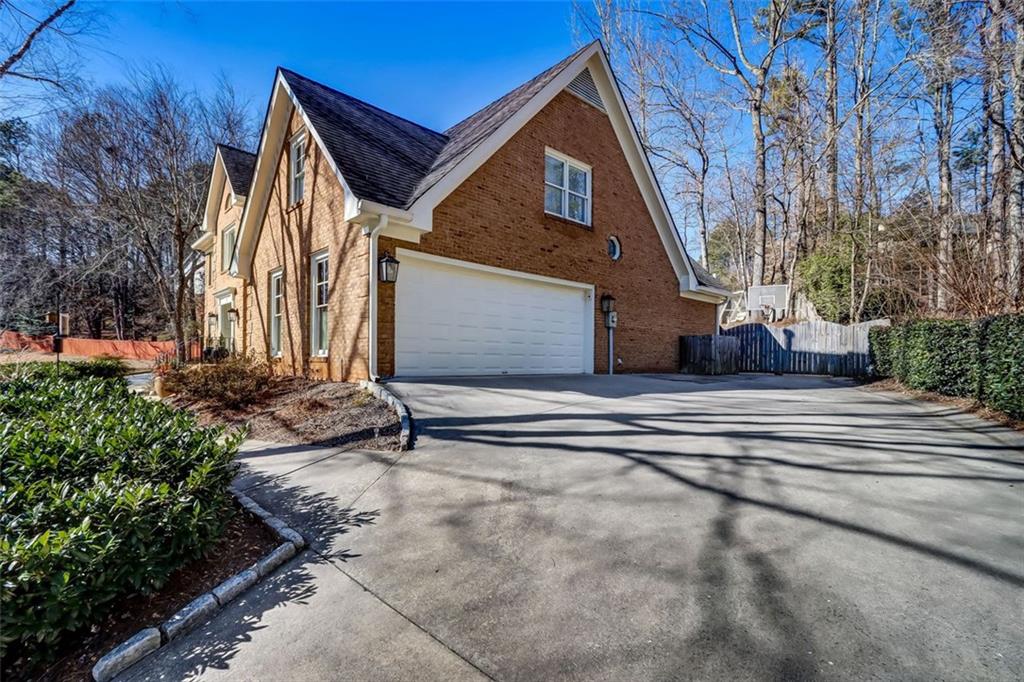 Sloped driveway with large parking pad at the top allows for turning around if needed