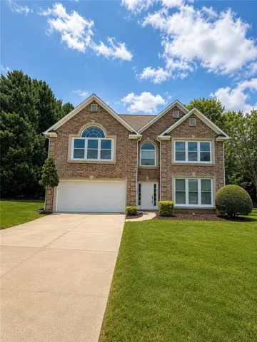 Two-story brick exterior featuring multiple gables and arched window accents