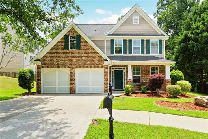 Brick and siding facade with a covered front porch featuring white columns