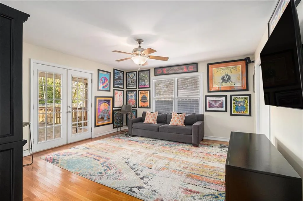 Living area with french doors, plenty of natural light, light wood-type flooring, and ceiling fan