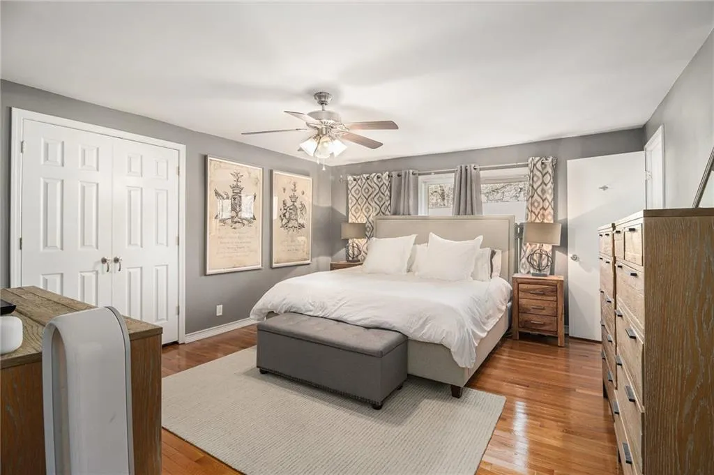 Bedroom featuring a ceiling fan, a closet, and wood finished floors
