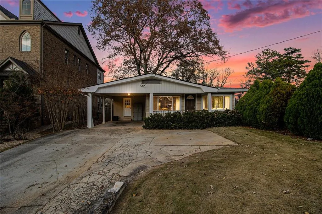 View of front of house with a lawn, concrete driveway, a carport, and covered porch