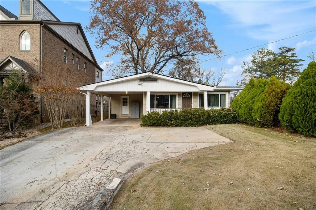 Bungalow-style house featuring driveway, a front yard, a porch, and an attached carport