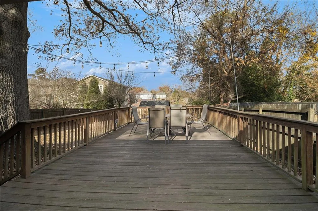Wooden deck with a fenced backyard and outdoor dining area