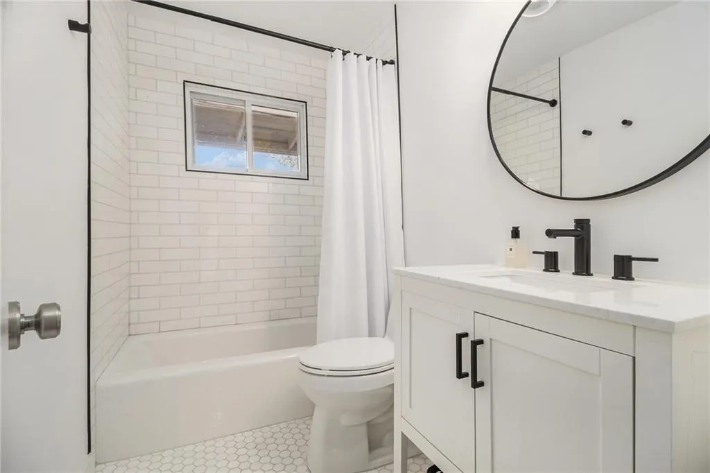 Full bath with vanity, shower / tub combo with curtain, and light tile patterned flooring