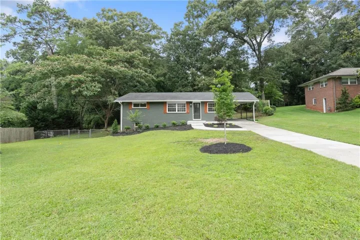 Ranch-style residence featuring a gray exterior, white trim, and a covered carport