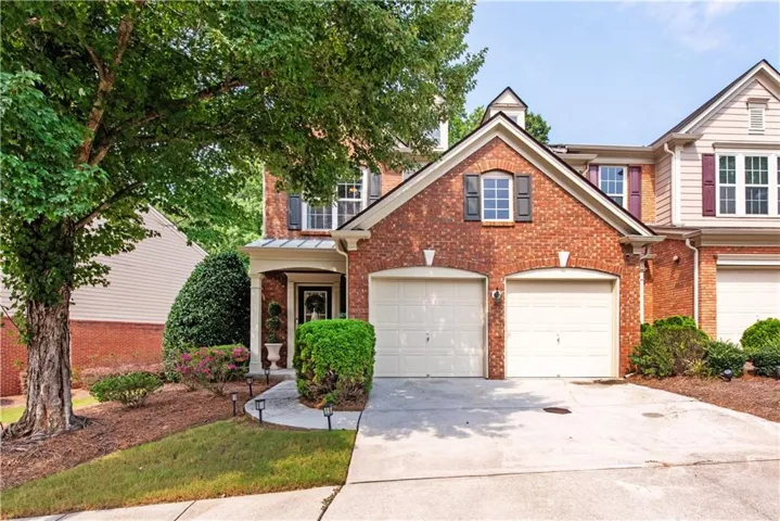 Brick exterior featuring a gabled roofline and decorative shutters