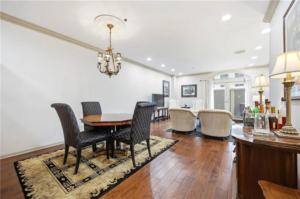 Dining area with ornamental molding, french doors, dark wood-style floors, and recessed lighting