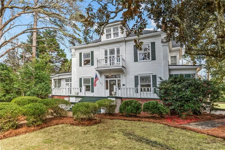 View of front facade with a front yard and a balcony