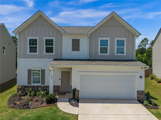 Two-story residence featuring a two-car garage, multiple gables, and a columned entry