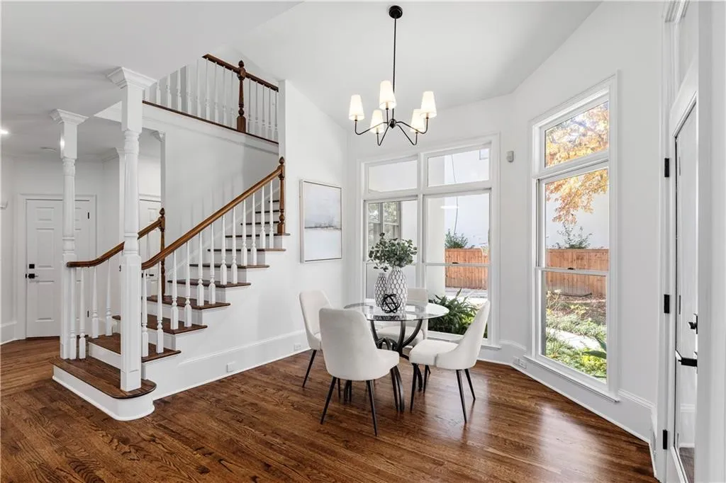 Dining area with dark wood finished floors, plenty of natural light, and stairs