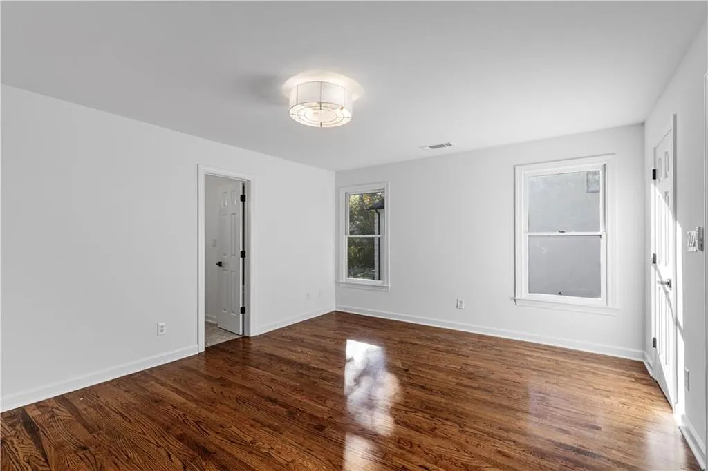 Unfurnished bedroom with dark wood-style flooring and baseboards