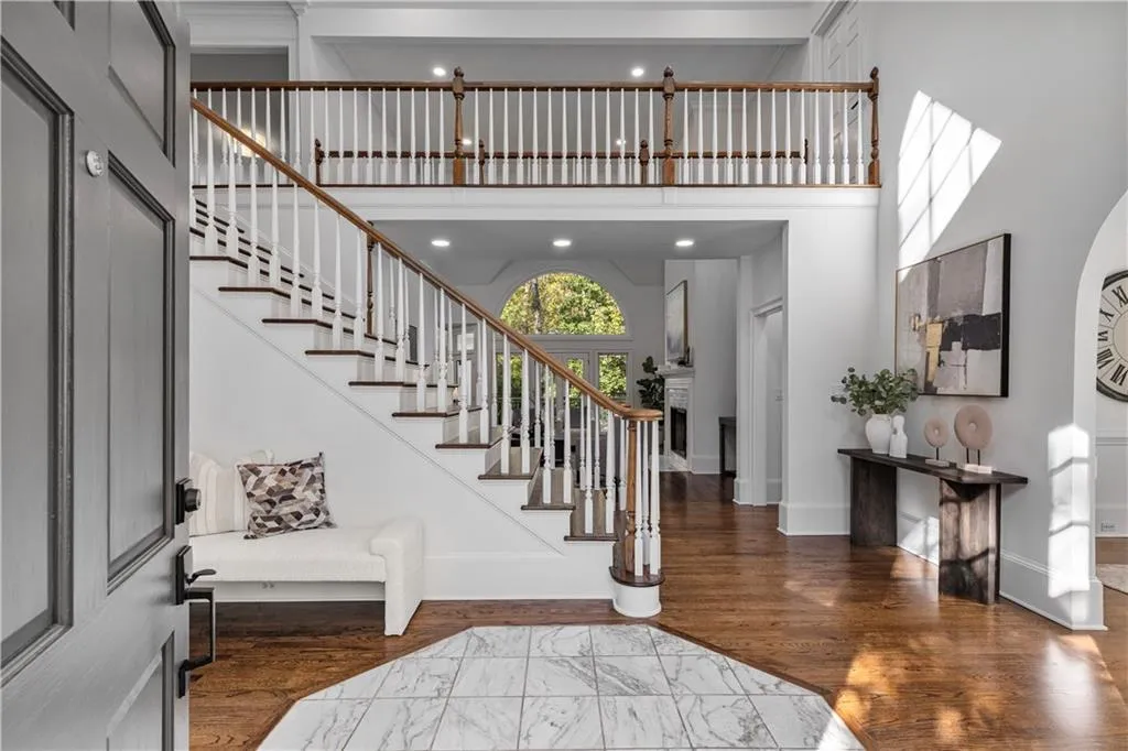 Entrance foyer with a fireplace, dark wood-style floors, stairs, a high ceiling, and recessed lighting