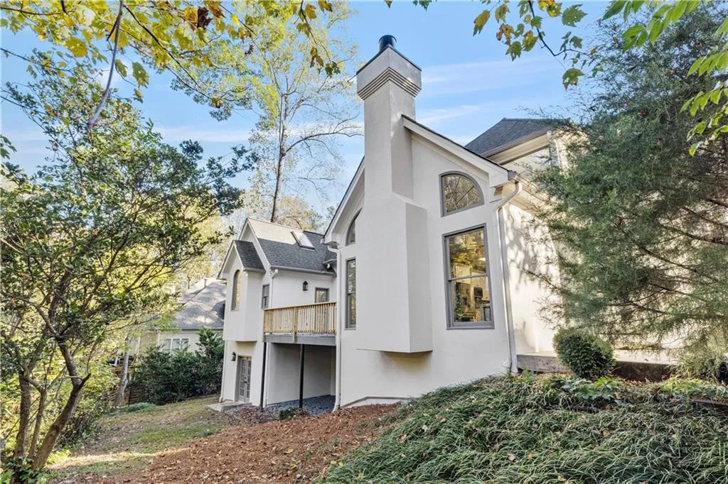 View of property exterior with stucco siding and a chimney