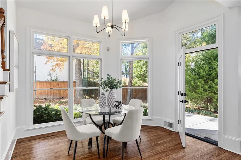 Dining area featuring wood finished floors, healthy amount of natural light, and a chandelier