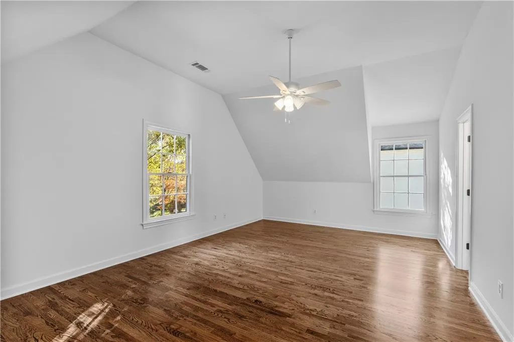 Bonus room featuring vaulted ceiling, dark wood-type flooring, and ceiling fan