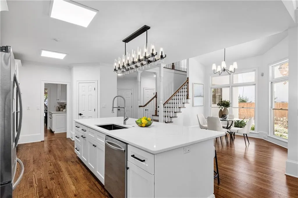 Kitchen featuring a chandelier, dark wood-style floors, pendant lighting, and white cabinets