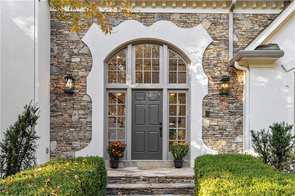 Doorway to property with stone siding and stucco siding