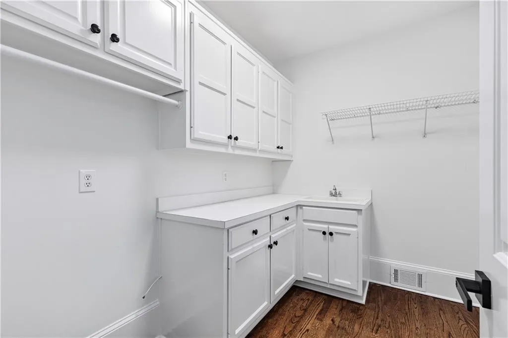 Washroom with dark wood-style flooring and baseboards