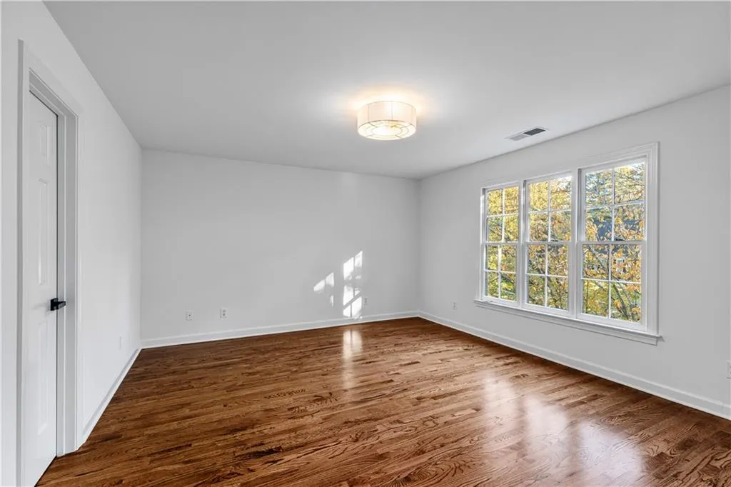 Spare room with dark wood-style floors and baseboards