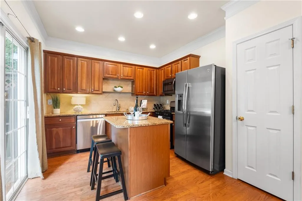 Kitchen featuring a kitchen island, appliances with stainless steel finishes, light-filled with hardwood-style flooring