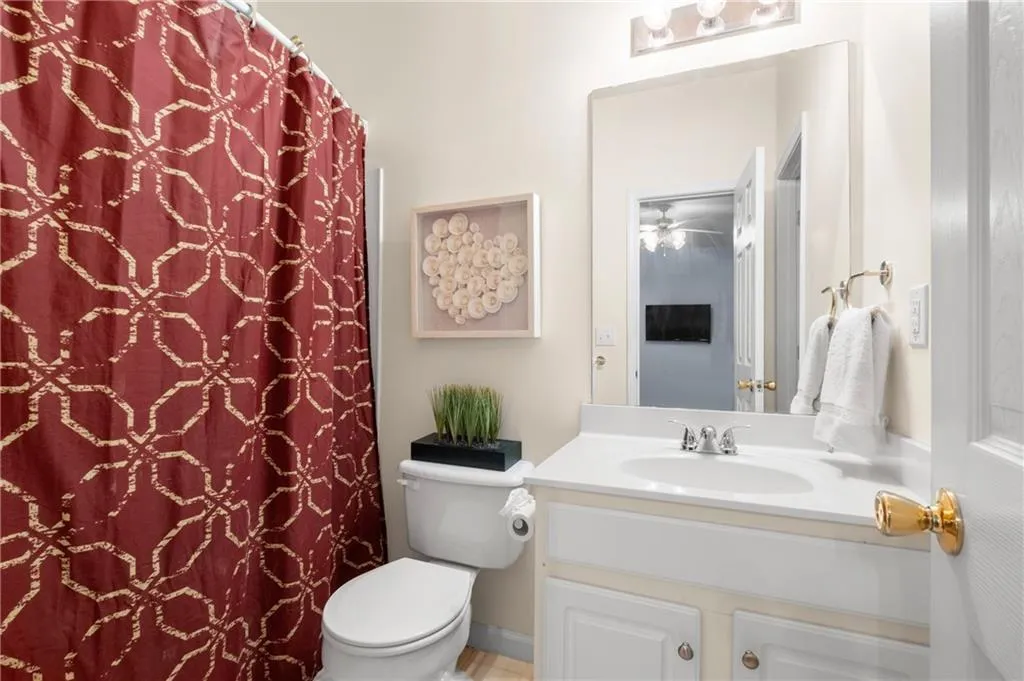Terrace level ensuite bathroom with circular shower rod, features a vanity, cabinet space and large closet