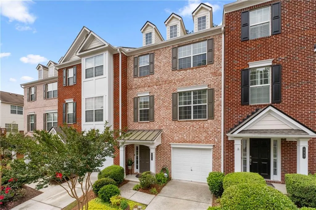 View of property featuring a single garage and only four units in the block. Guest parking is located a short distance down the street