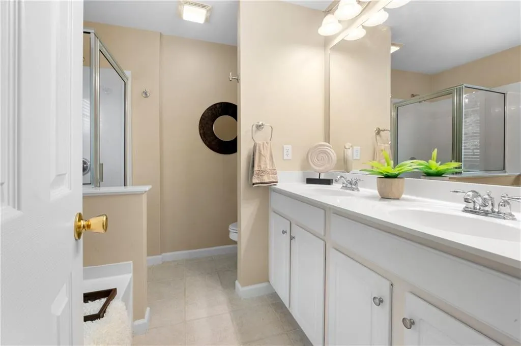 Primary bathroom features a separate shower and soaking tub, a large double vanity, and tile flooring
