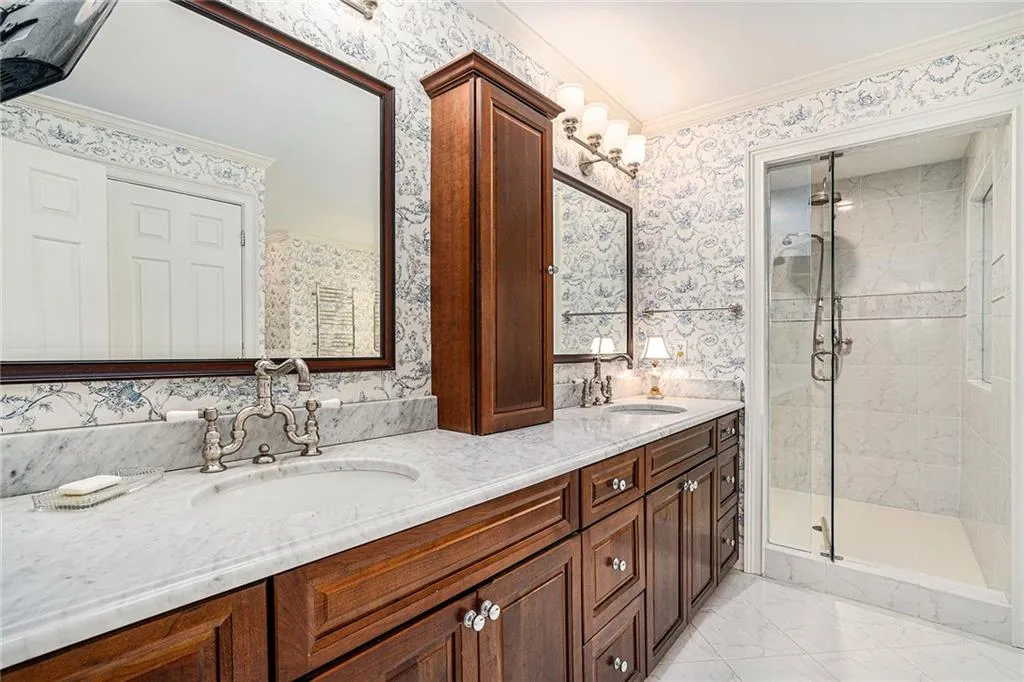 spacious double vanity and view of shower