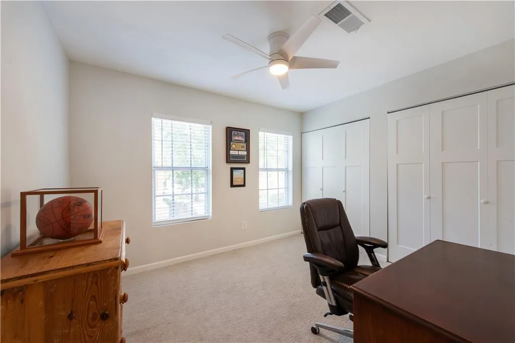 Office with a ceiling fan and carpet flooring