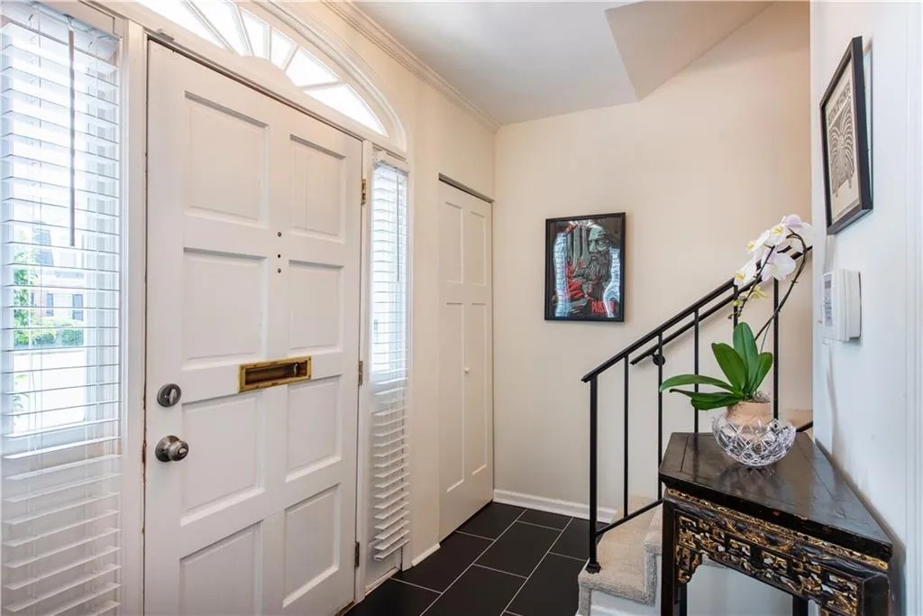 Entryway with dark tile patterned flooring and baseboards