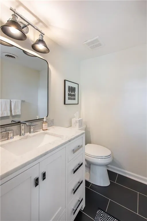 Half bathroom featuring vanity and tile patterned flooring