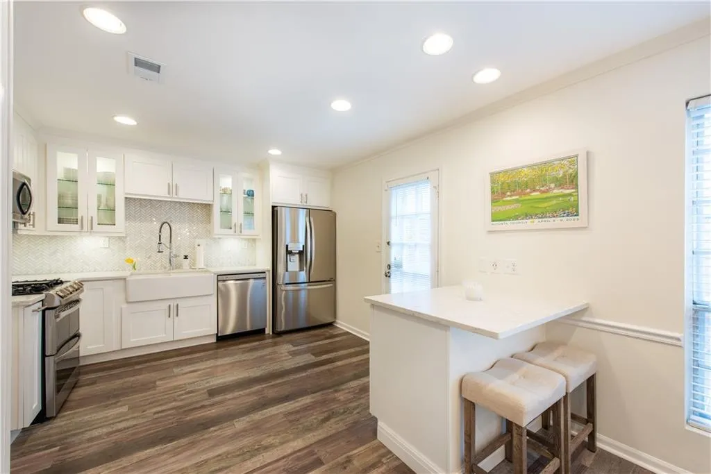 Kitchen with appliances with stainless steel finishes, a breakfast bar, a peninsula, crown molding, and backsplash
