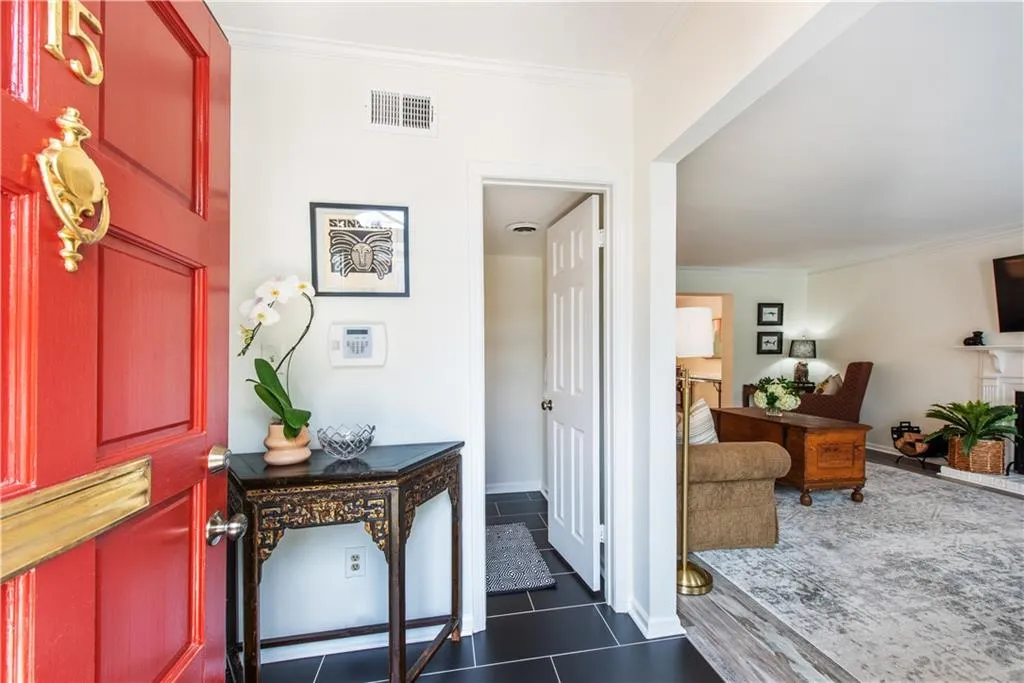 Foyer entrance featuring crown molding and dark tile patterned flooring