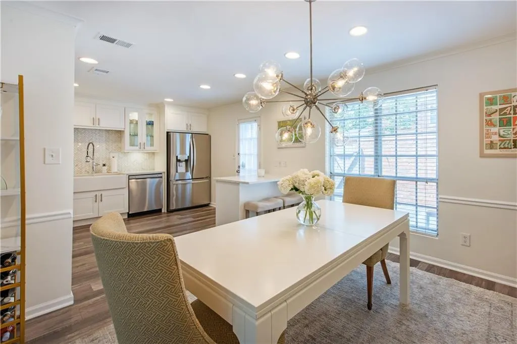 Dining area featuring dark wood finished floors, healthy amount of natural light, recessed lighting, a chandelier, and ornamental molding