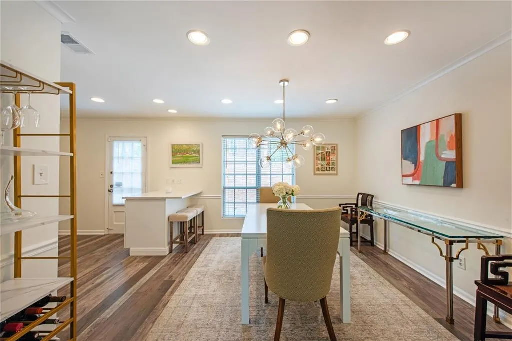 Dining room with crown molding, wood finished floors, recessed lighting, and a chandelier
