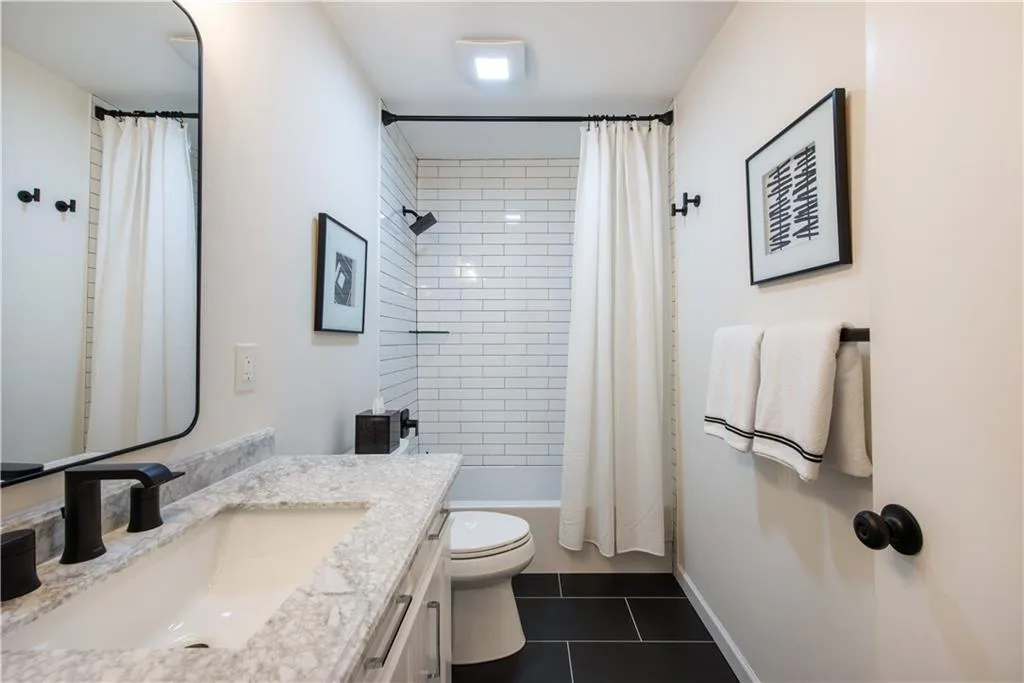 Bathroom with vanity, tile patterned flooring, and shower / tub combo with curtain