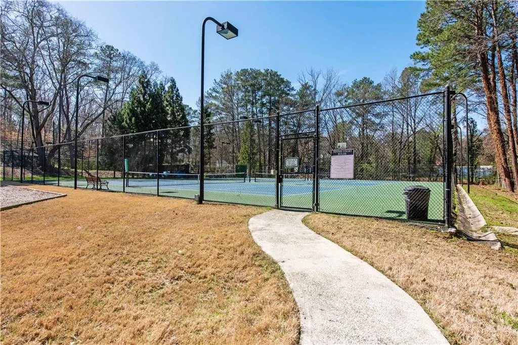 View of tennis court featuring a gate