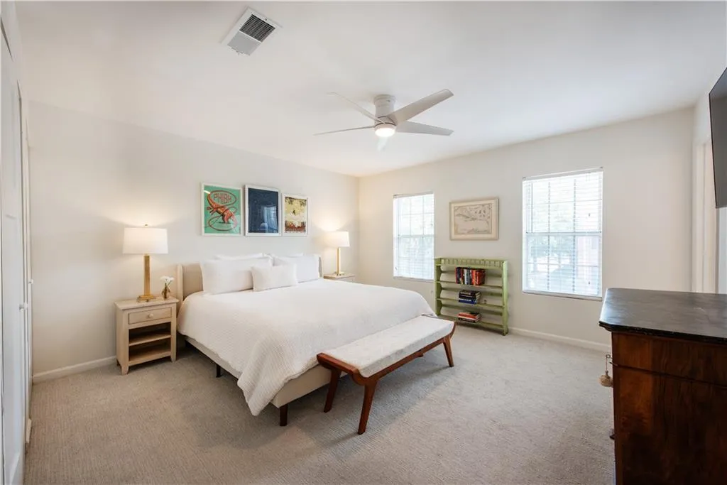 Bedroom with light carpet and a ceiling fan