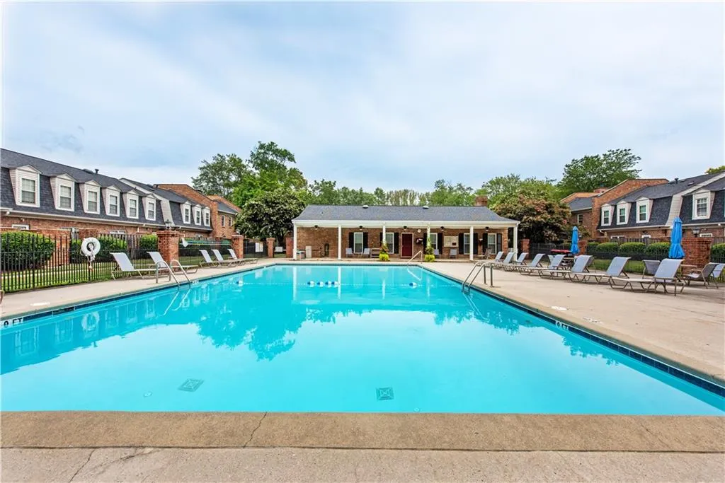 Community pool with a patio area and a residential view