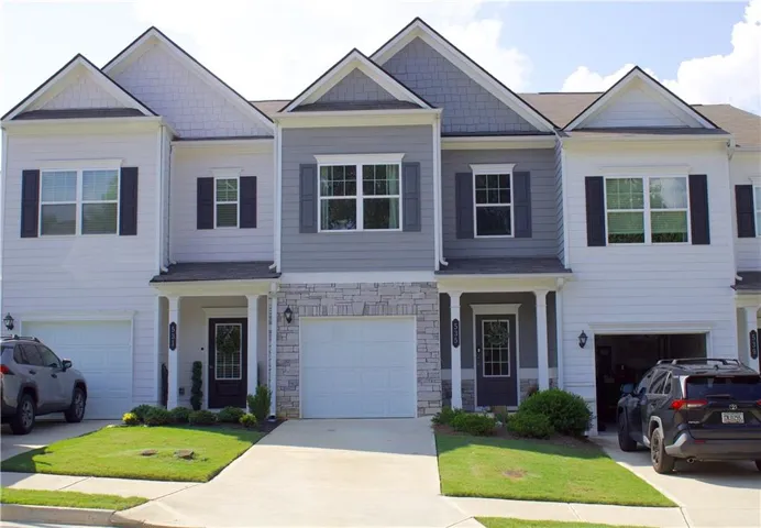 Townhome exterior with a mixed material façade, featuring horizontal siding, shake siding, and stone accents