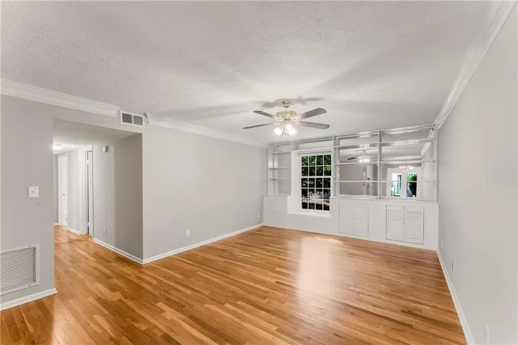 Large gathering space has garden view, built-in window seat, book cases + cabinets.