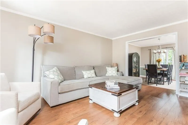 Living room featuring crown molding, wood-type flooring, and a chandelier