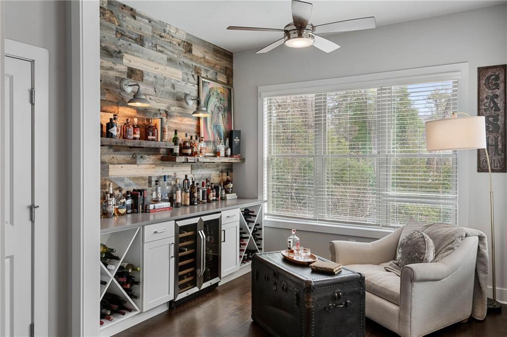 Bar with dark hardwood / wood-style floors, ceiling fan, white cabinets, and wine cooler