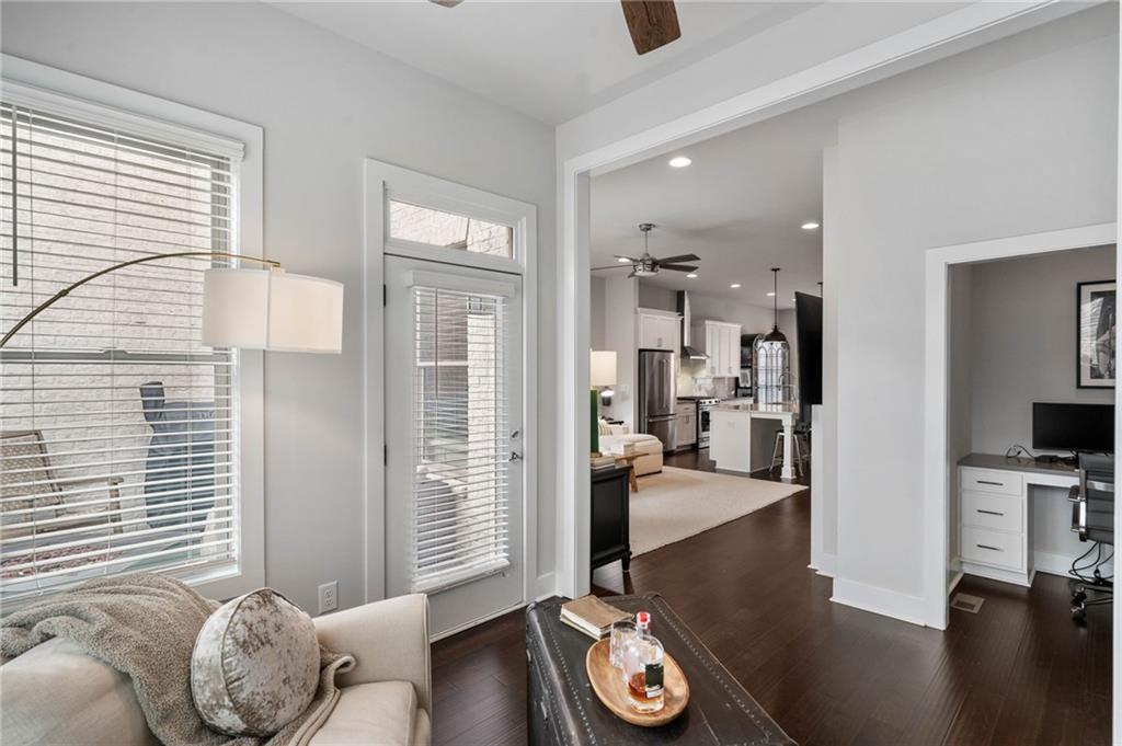 Living room with dark hardwood / wood-style flooring and ceiling fan