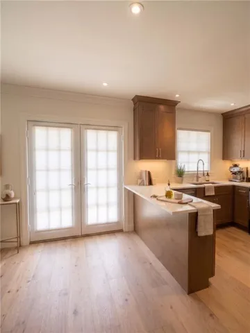 Kitchen featuring wood-finish flooring, recessed lighting, and a peninsula with a light-toned countertop