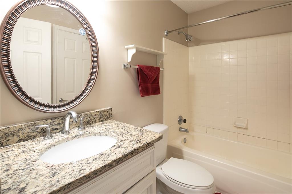 Full bathroom with toilet, tiled shower / bath combo, and large vanity